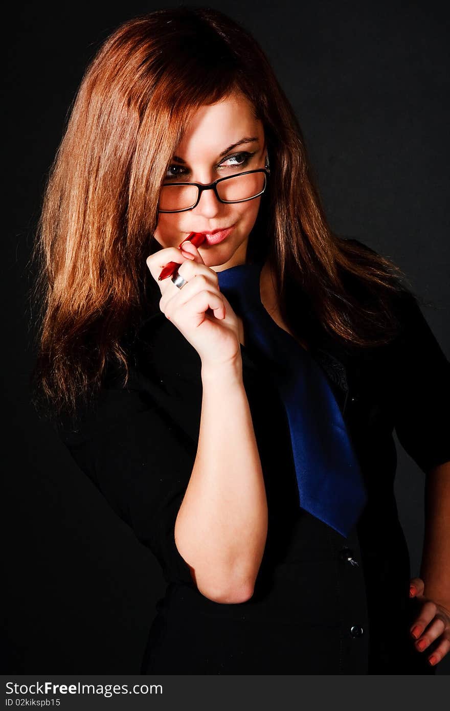 Picture of a young charming girl in black bouse on black background.