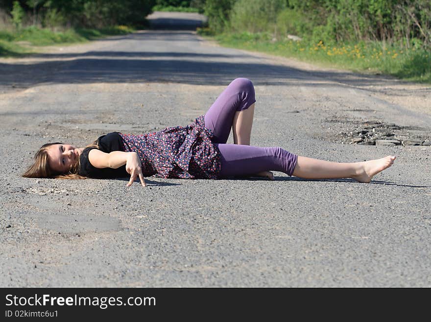 Beauty smiling teenage girl lying on old rural road. Beauty smiling teenage girl lying on old rural road