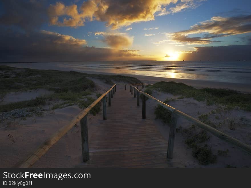 Image of a wooden walkway going on a beach. Image of a wooden walkway going on a beach