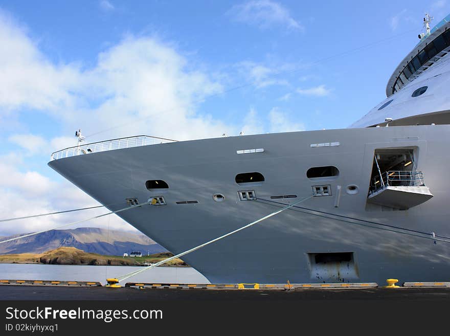 The image of the cruise ship's bow against icelandic mountainous landscape. The image of the cruise ship's bow against icelandic mountainous landscape