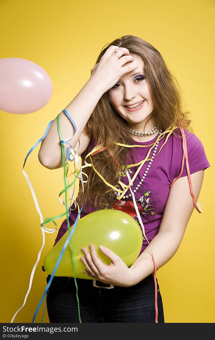 Young pretty girl with balloons and paper streamer in studio