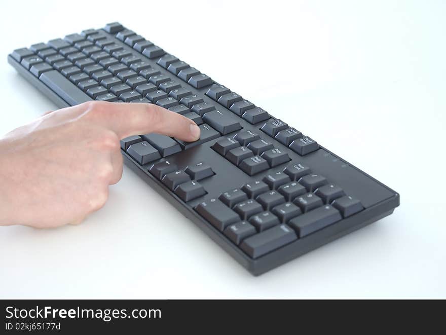 A keyboard with a hand, pressing enter. A keyboard with a hand, pressing enter