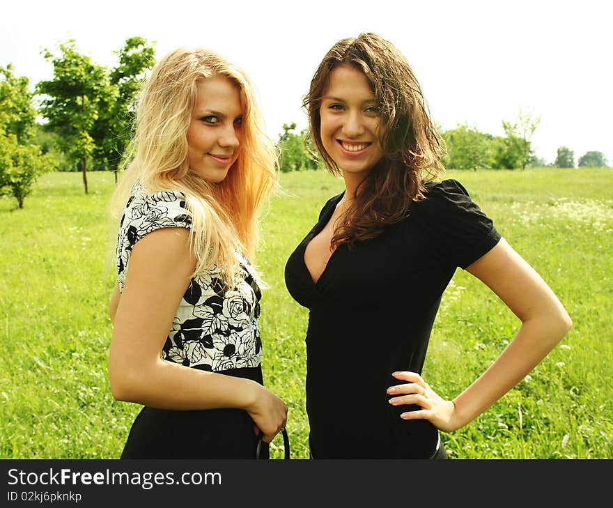 Two young beautiful girls outdoor summer time