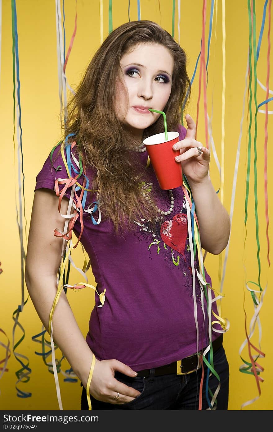 Pretty girl with cup and paper streamer in studio. Pretty girl with cup and paper streamer in studio