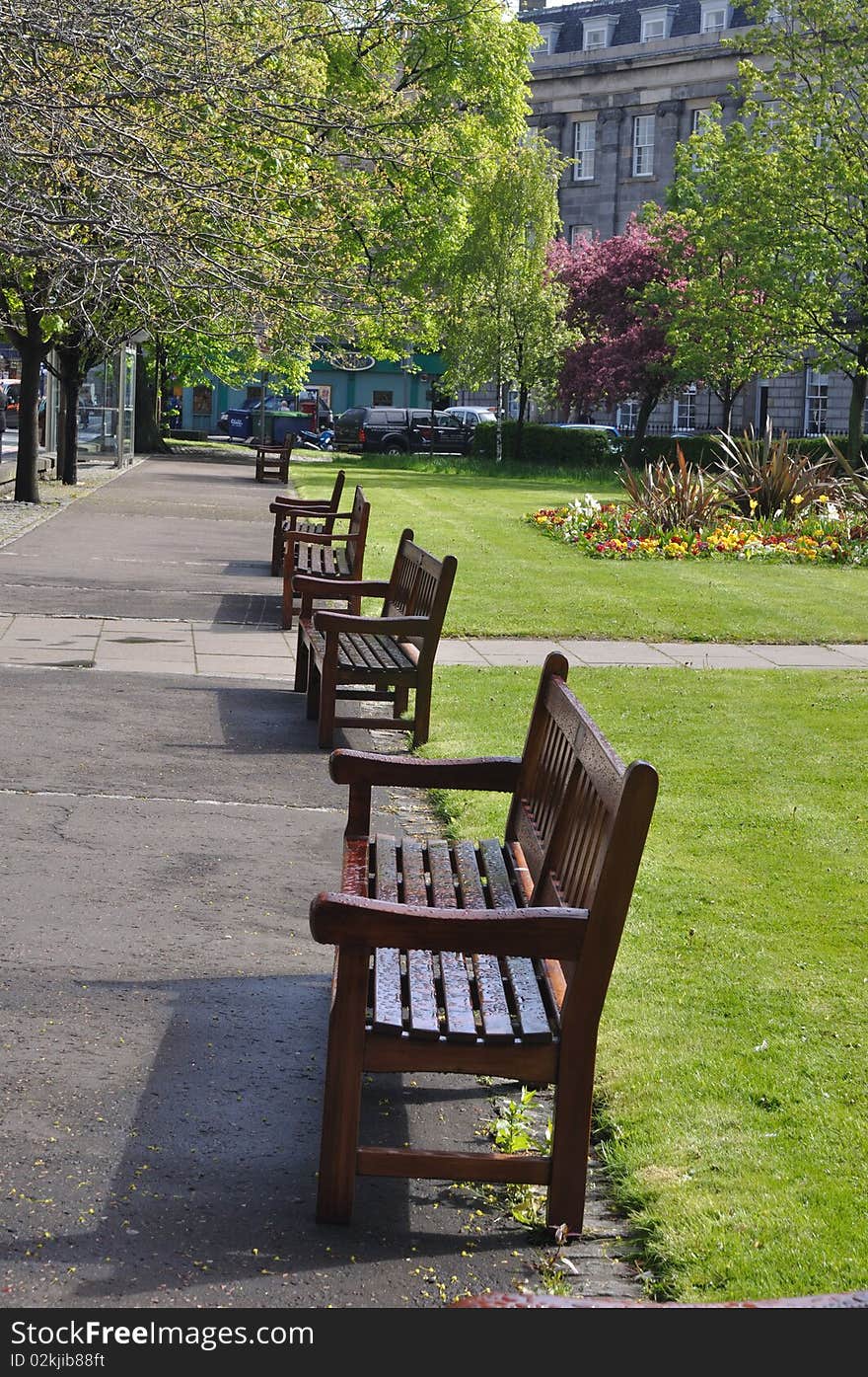 Row of empty bench in park in the middle of city, Edinburgh