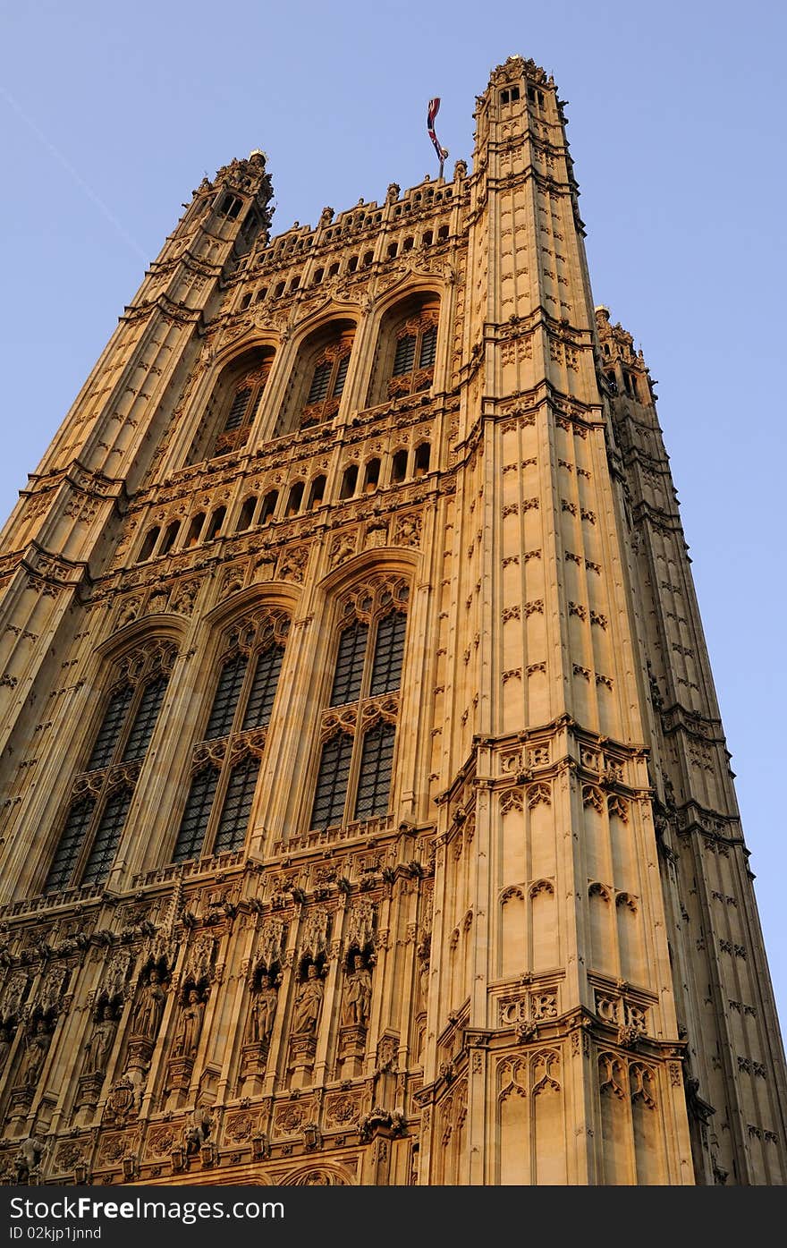 United Kingdom flag on Houses of Parliament from London, blue sky in background. United Kingdom flag on Houses of Parliament from London, blue sky in background