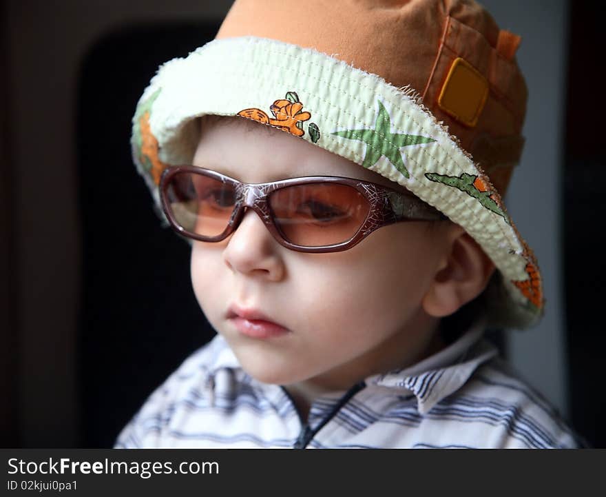 Fashionable little boy with sunglasses and hat