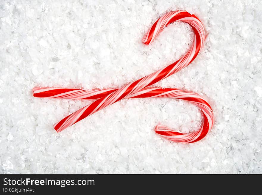 Image of two crossed candy canes lying in the snow. Image of two crossed candy canes lying in the snow