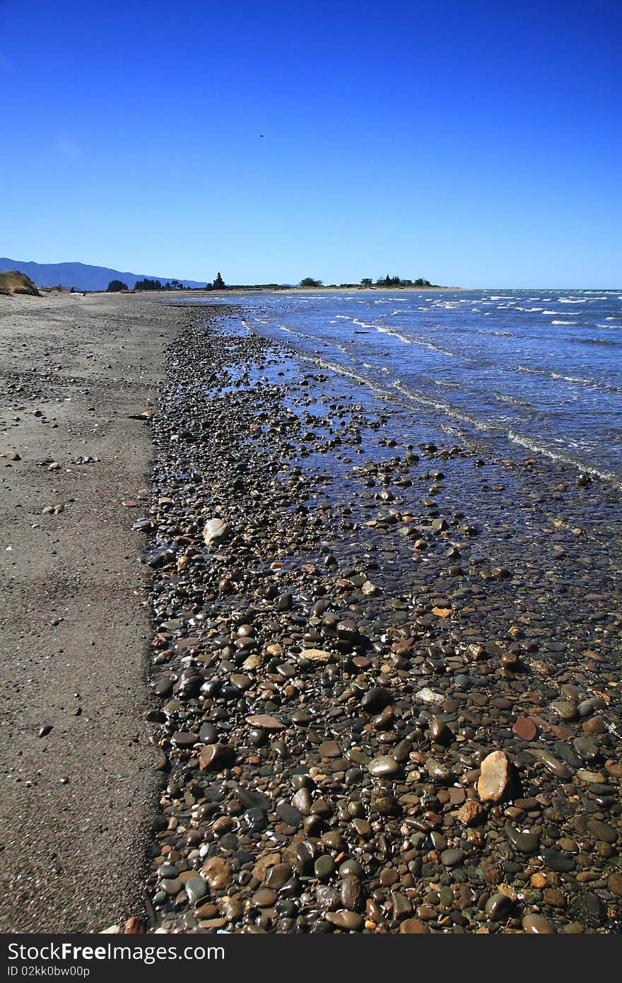 It's a a beach with a border between the sand and the stones