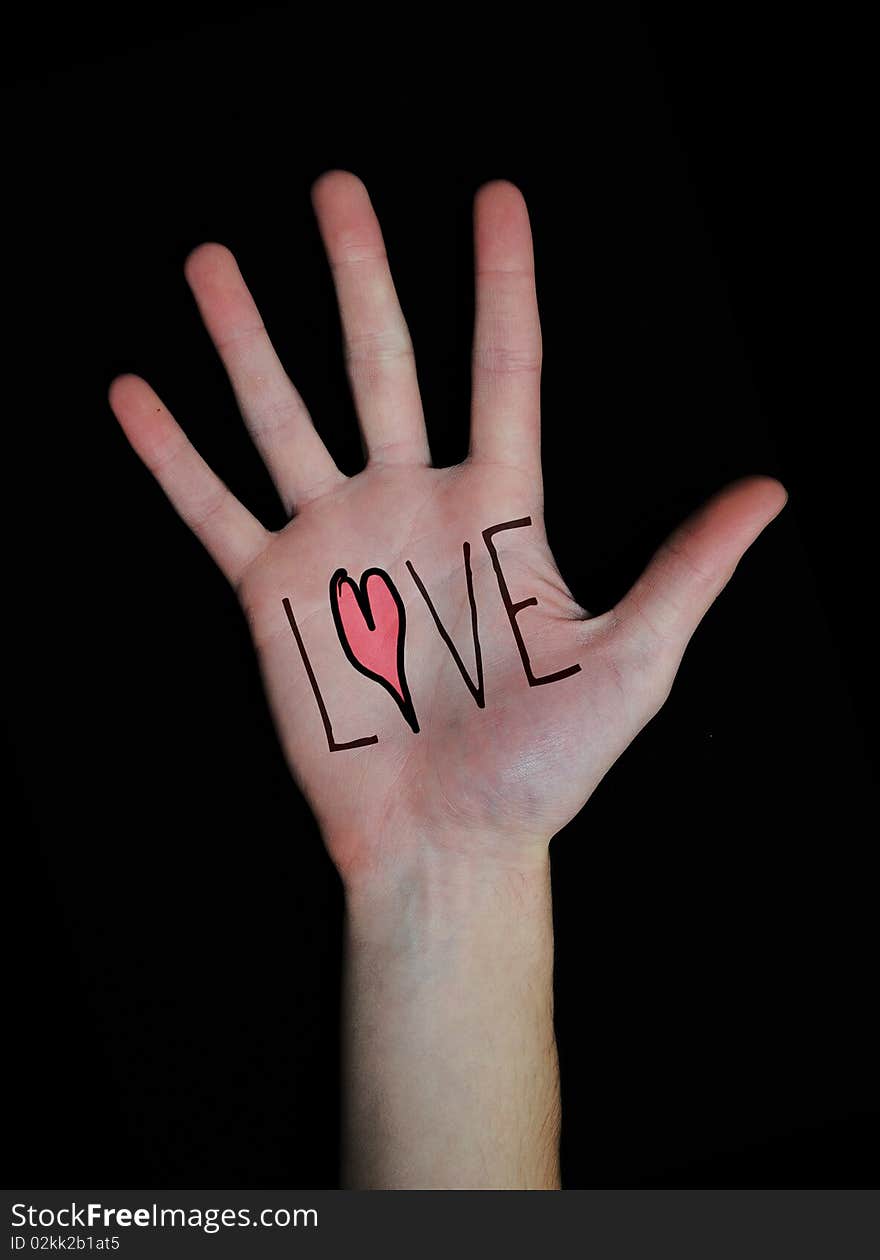 The word love written on a teenager's white Caucasian hand isolated on black background. The word love written on a teenager's white Caucasian hand isolated on black background.