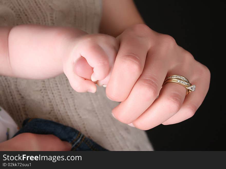 Caucasian mother and baby, baby holding mother's thumb