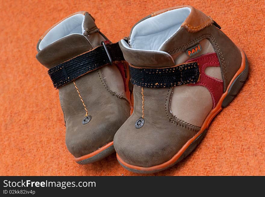 Children shoes on a orange background. Children shoes on a orange background