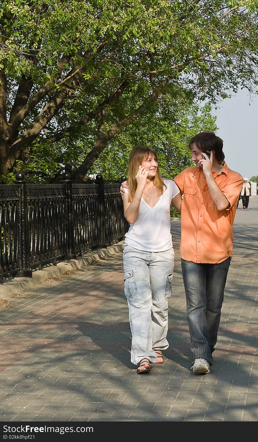 Girl and boy talking on the phone in the city