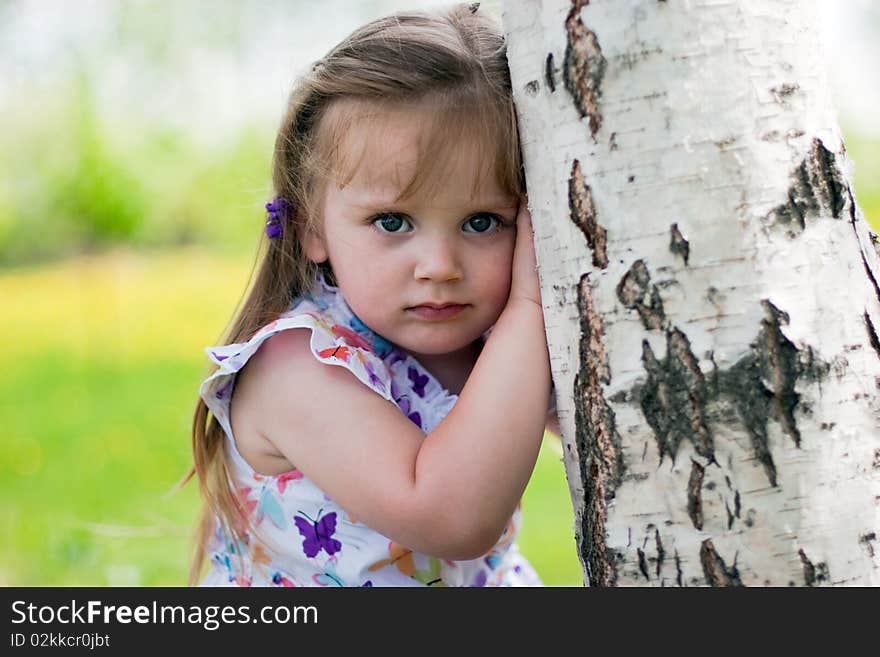 Little seriuos girl near birch. Little seriuos girl near birch