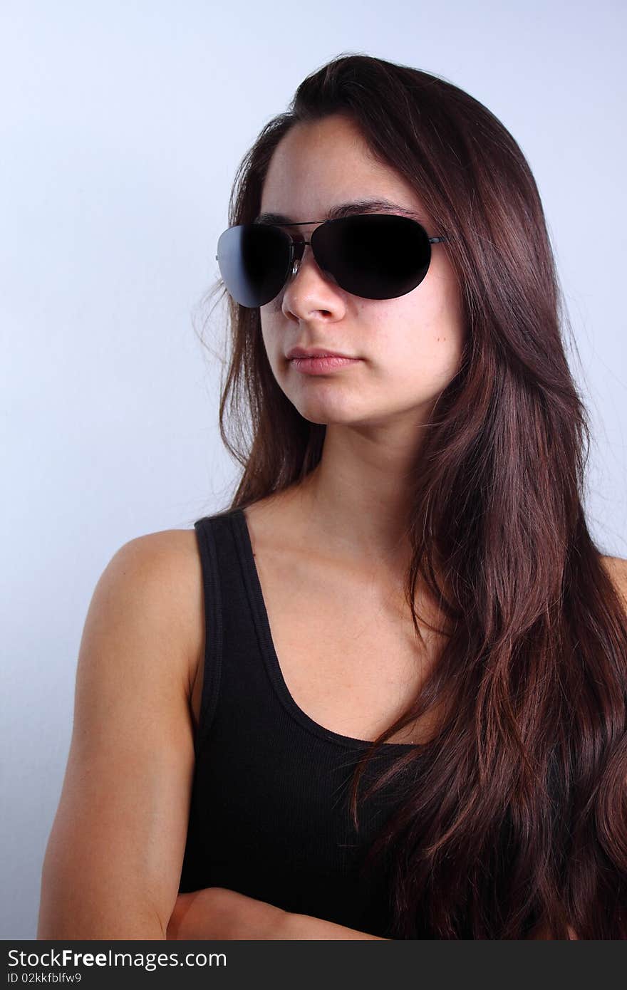 Portrait of a beautiful young woman with long brown hair wearing black shirt and sunglasses. Portrait of a beautiful young woman with long brown hair wearing black shirt and sunglasses