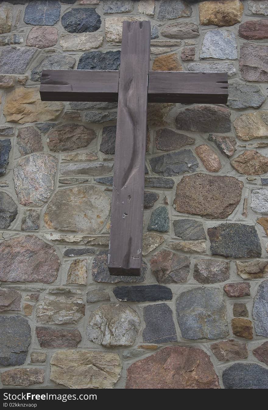 Wooden cross on stone wall background. Wooden cross on stone wall background