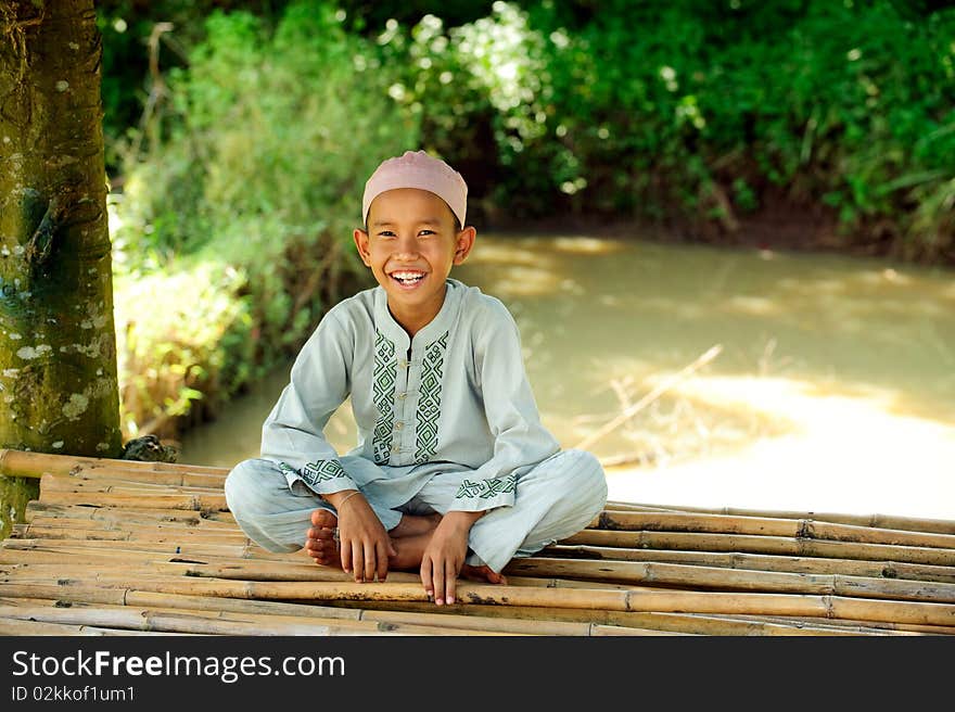 Happy Indonesian boy , sitting on bamboo. Happy Indonesian boy , sitting on bamboo