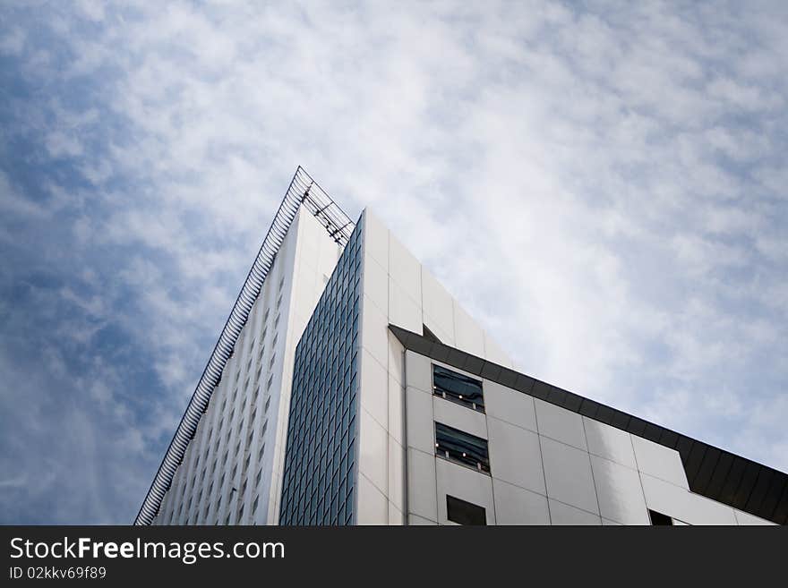 Detail shot of an office building in Tokyo, with triangular composition and shot against a beautiful slightly overcast blue sky. Detail shot of an office building in Tokyo, with triangular composition and shot against a beautiful slightly overcast blue sky.