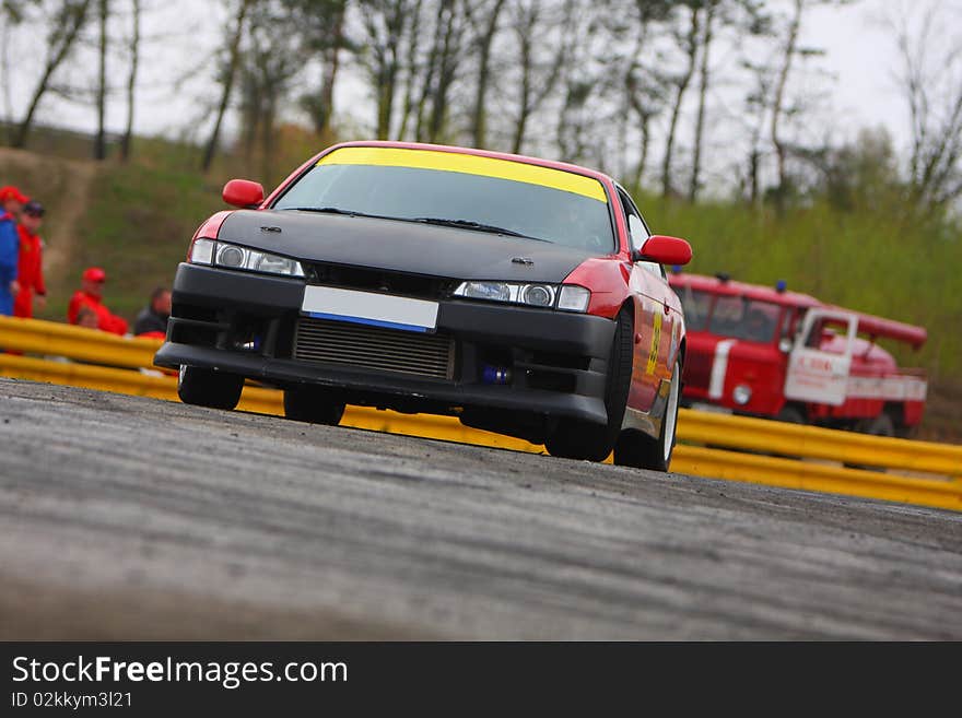 Black and red sport race car on track and yellow wall on background. Black and red sport race car on track and yellow wall on background