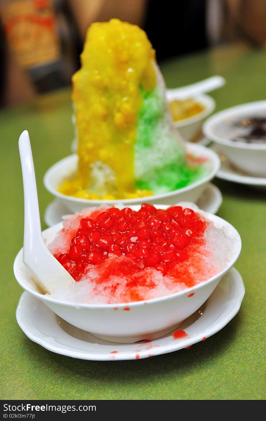 Bowl of ice kacang (red bean) dessert with mango and corn topping, and red ruby dessert. Bowl of ice kacang (red bean) dessert with mango and corn topping, and red ruby dessert