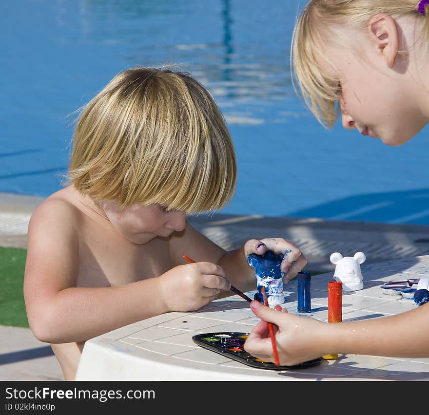 A little girls draws near the pool. A little girls draws near the pool