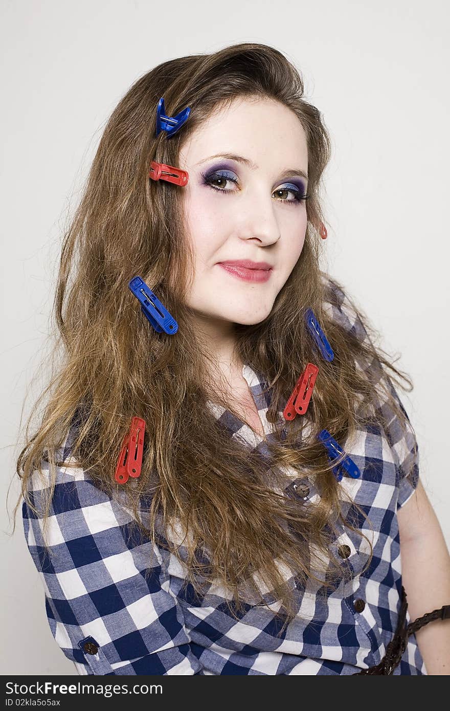 Young pretty woman with clothespin on the hair in studio