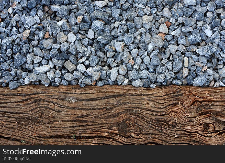 Texture of crashed grey granite gravel background and wood. Texture of crashed grey granite gravel background and wood