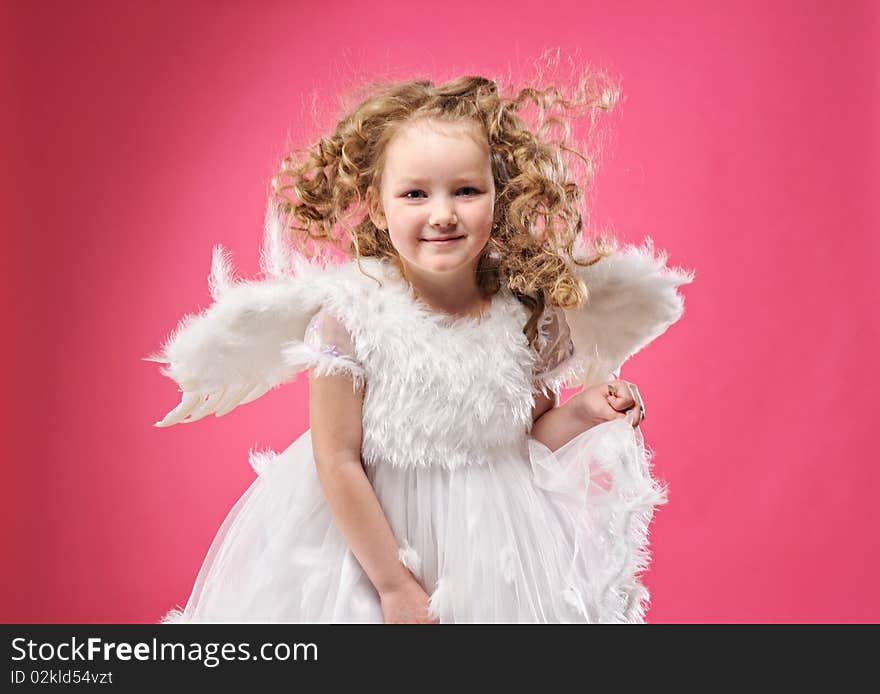 Beautiful little angel girl isolated on pink background