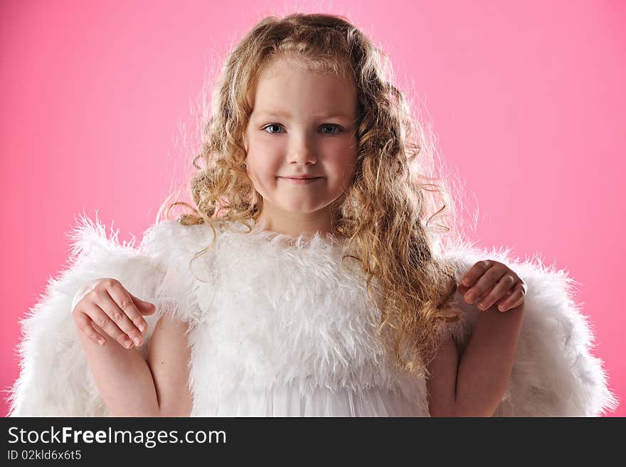 Beautiful little angel girl isolated on pink background