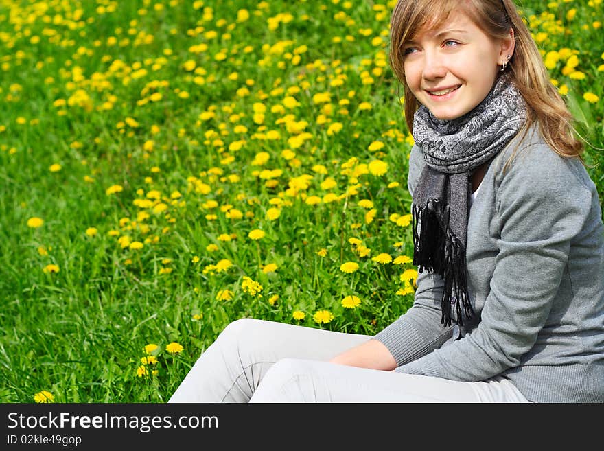 The young girl, sits on a green grass, in park. The young girl, sits on a green grass, in park