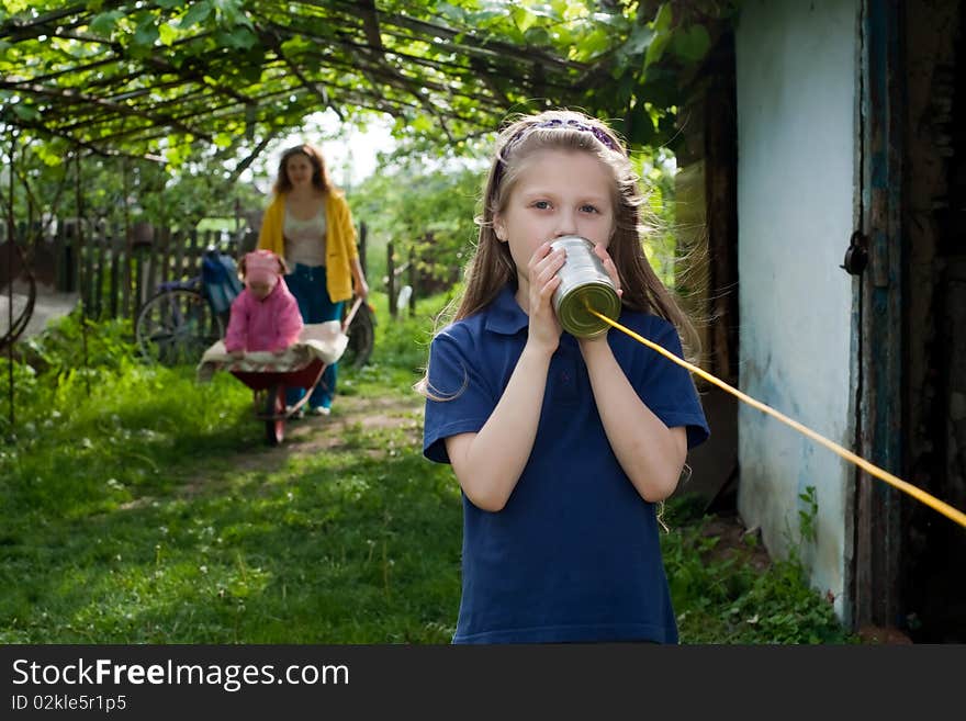 A girl with a toy-telephone and her mother and sister. A girl with a toy-telephone and her mother and sister