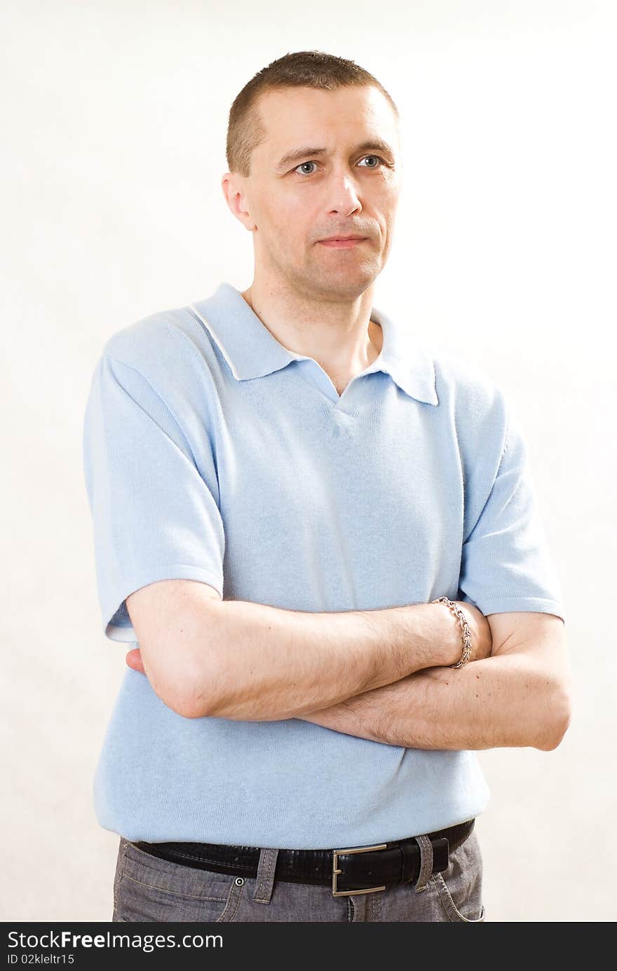 Man in a blue shirt standing on a white. Man in a blue shirt standing on a white