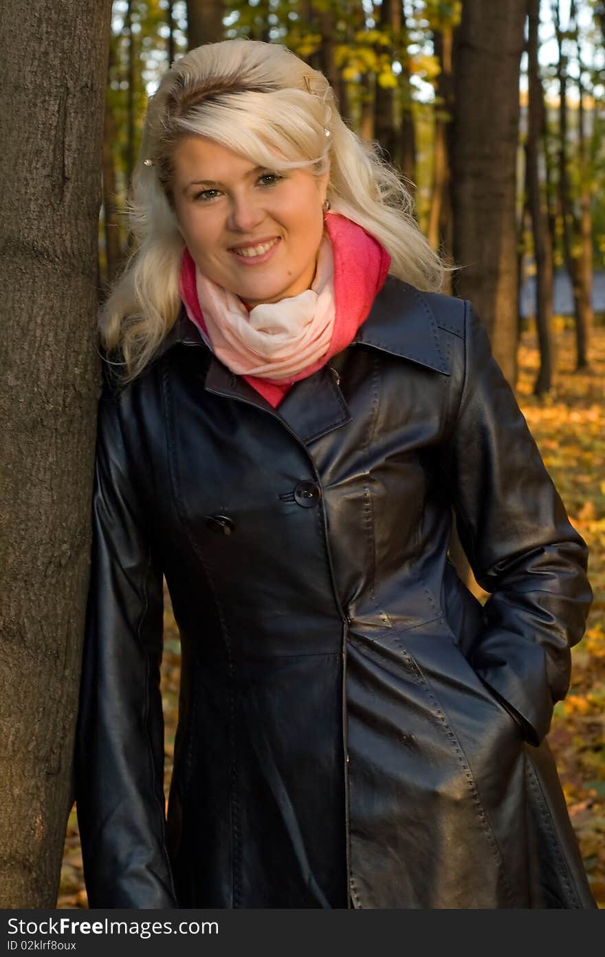 Woman in a leather coat walks in autumn park. Woman in a leather coat walks in autumn park