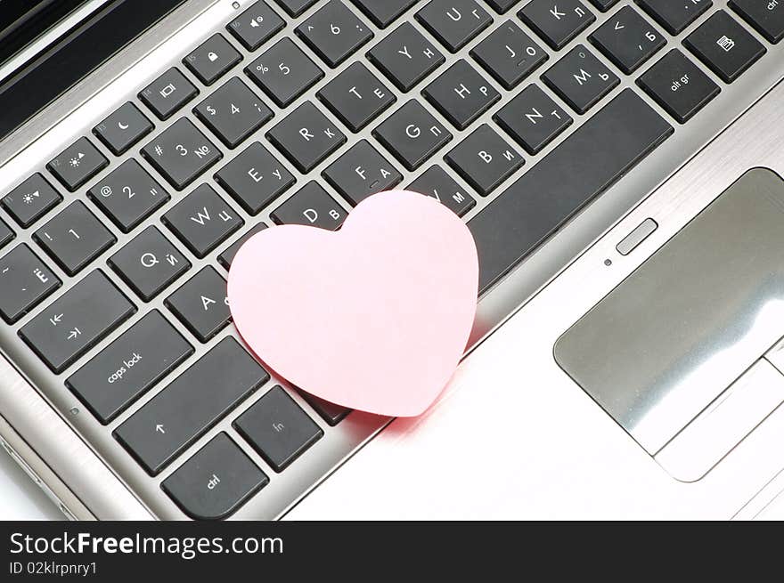 Black laptop keyboard with pink sticker. Black laptop keyboard with pink sticker