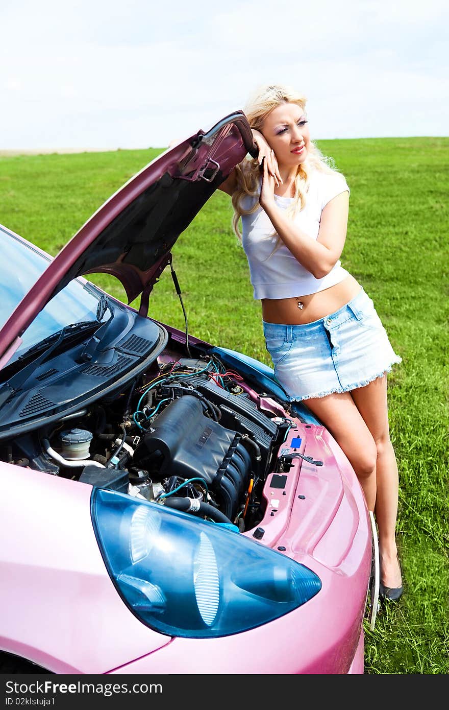 Beautiful young woman repairing her car outdoor on a summer day. Beautiful young woman repairing her car outdoor on a summer day