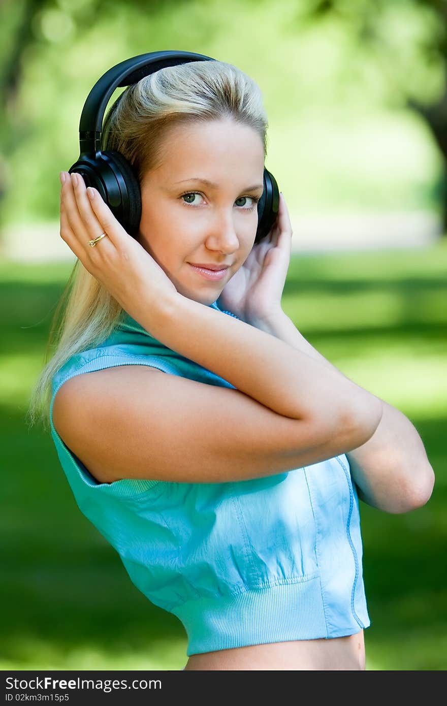 Girl with headphones in park, outdoors