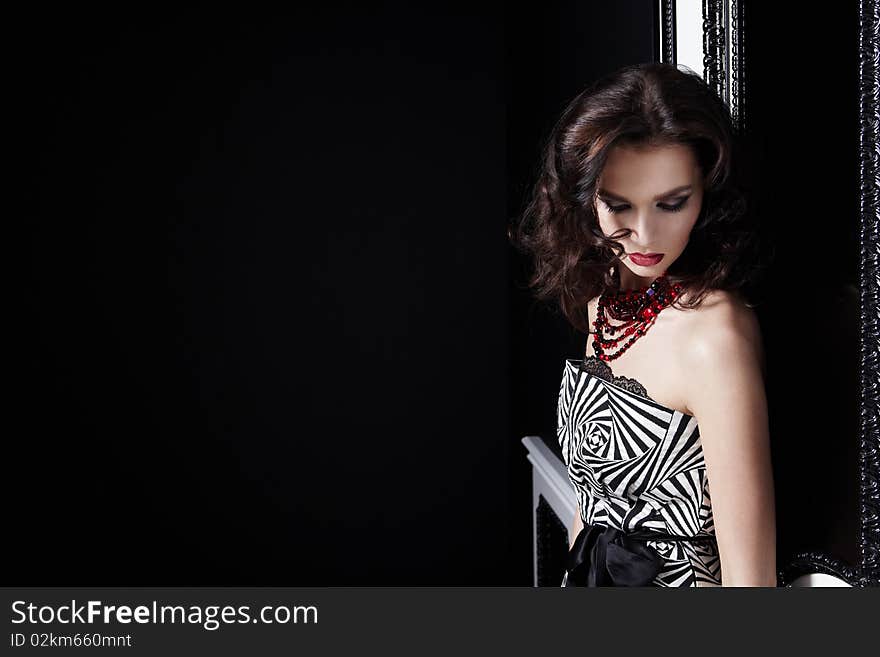 Portrait beautiful the girl with a make-up and a hairdress on a black background. Portrait beautiful the girl with a make-up and a hairdress on a black background