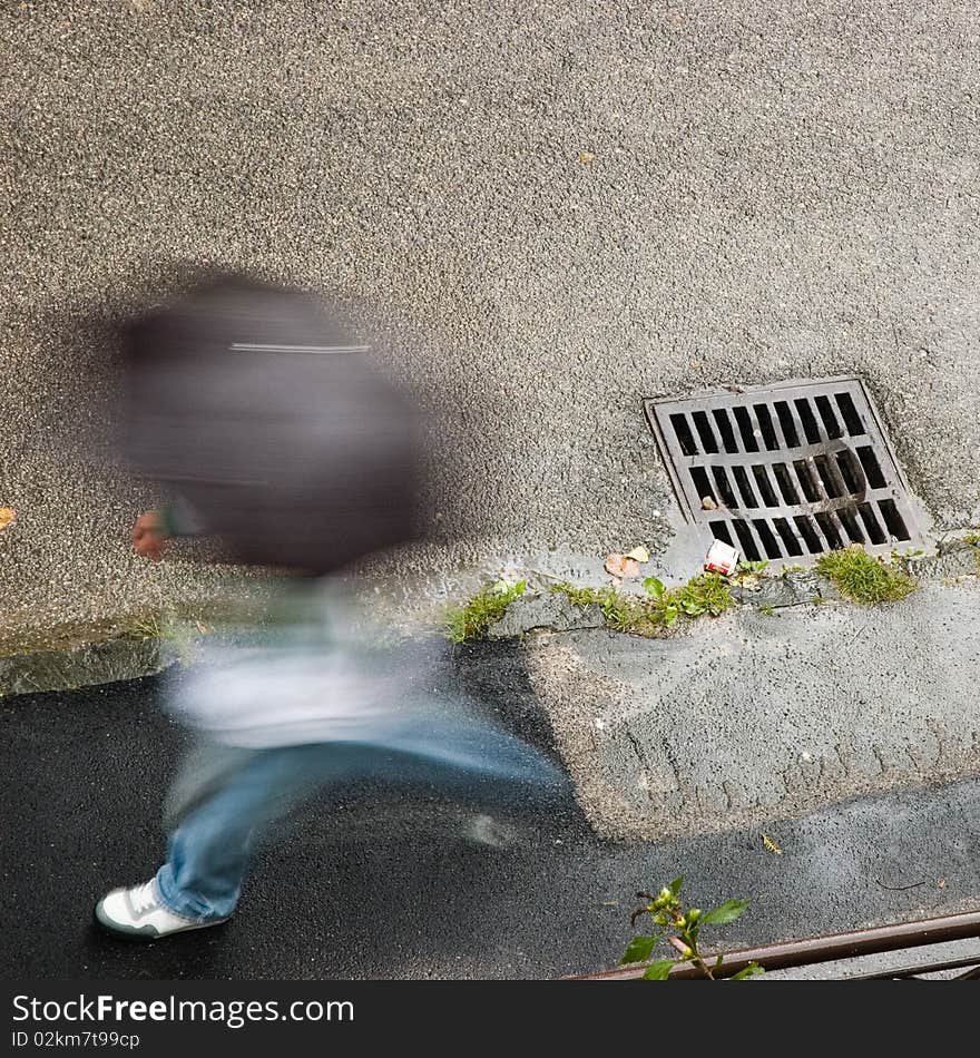 Walking in the rain, blurred figure with umbrella