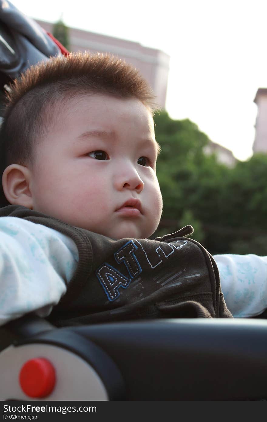 Lovely Chinese baby is sitting under sunshine. Lovely Chinese baby is sitting under sunshine