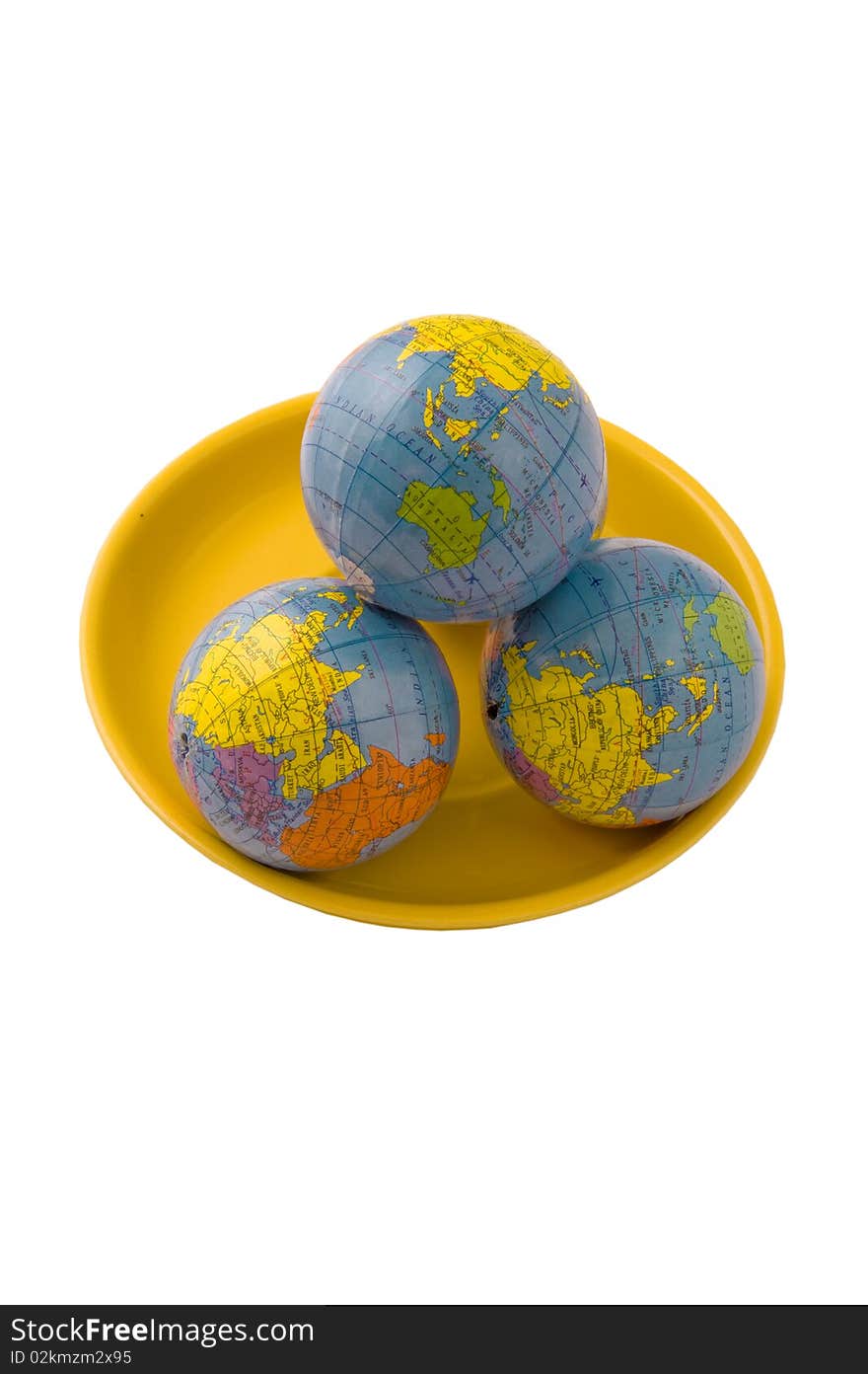 Three models of globes on the yellow plate and isolated on the white. Three models of globes on the yellow plate and isolated on the white