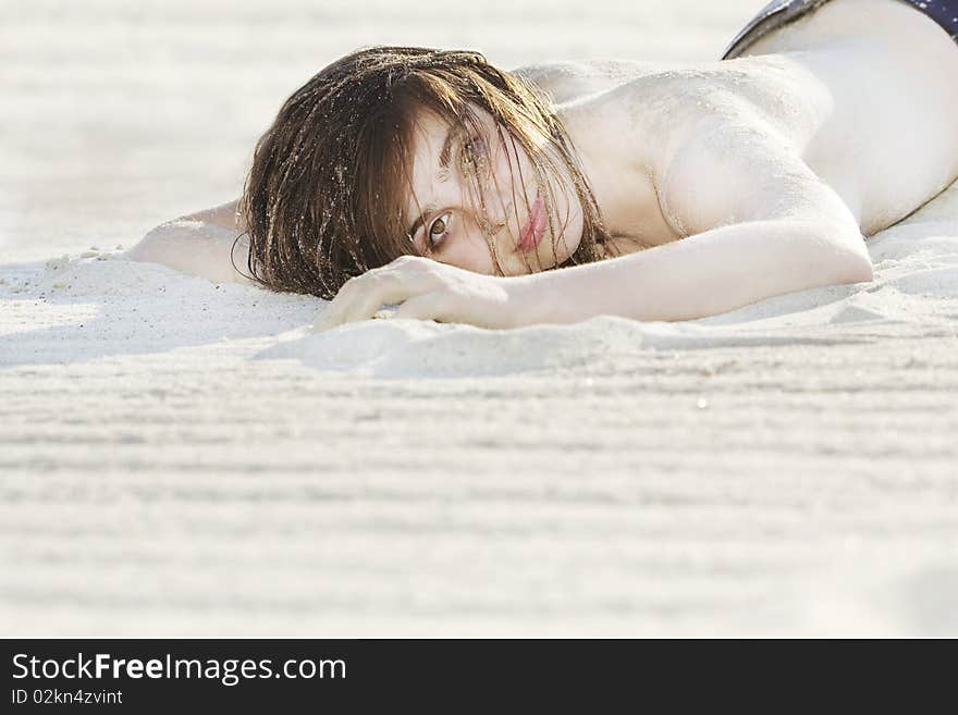 Beautiful Woman Laying On The Sand