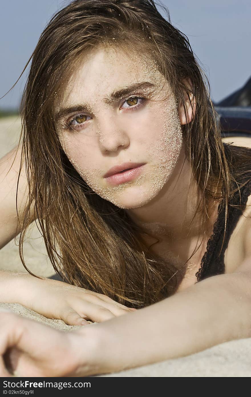 Portrait of beautiful fashion model laying on the sand. Portrait of beautiful fashion model laying on the sand