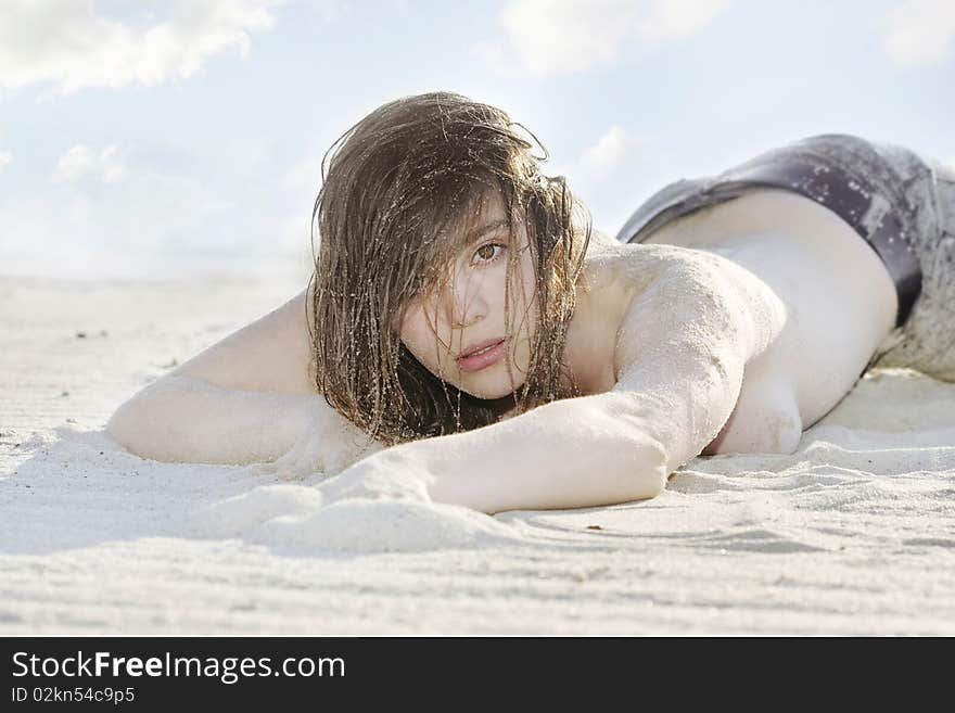 Model laying on the sand