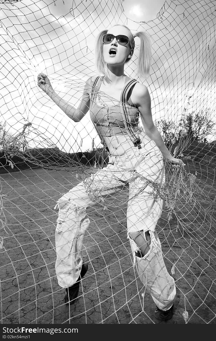 Fashion model standing behind net webbing