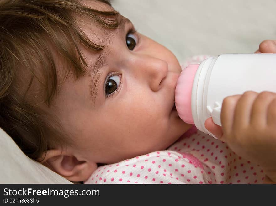 Small child eats from bottle. Small child eats from bottle