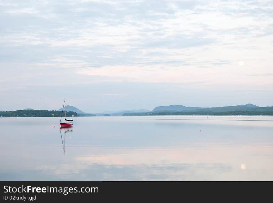 Sailboat reflection creating an arrow shaped mirror effect.