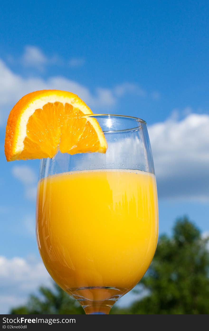 A refreshing glass of orange juice while sitting outdoors.