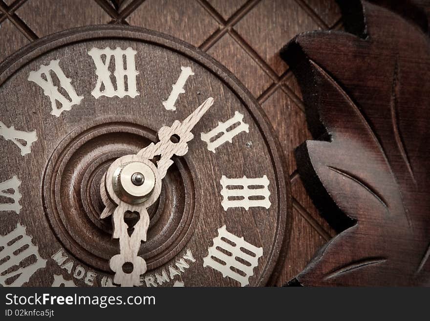 Close-up of an old wooden cuckoo clock with roman numerals. Close-up of an old wooden cuckoo clock with roman numerals