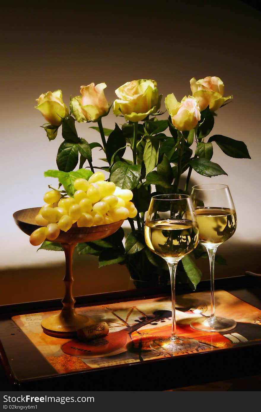 Still-life with white wine, grapes and flowers.