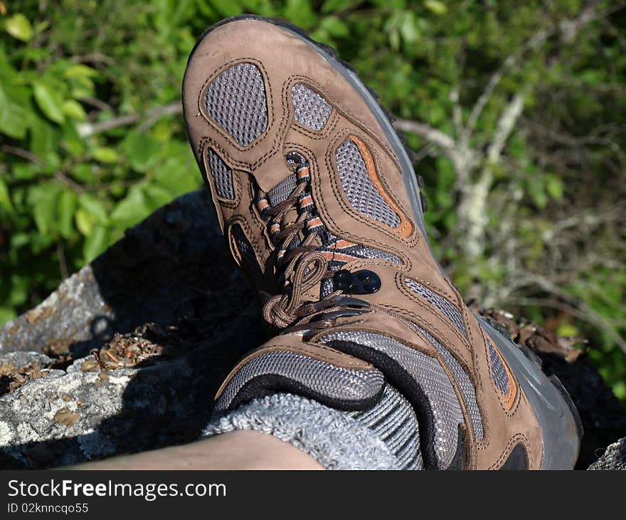 One foot hanging on the edge of mountain side as the person climbs down.